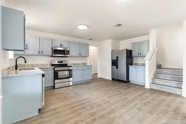 a kitchen with stove cabinets and refrigerator