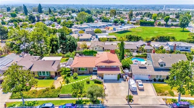 an aerial view of residential houses with outdoor space and parking