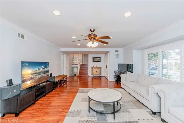a living room with furniture a flat screen tv and a large window