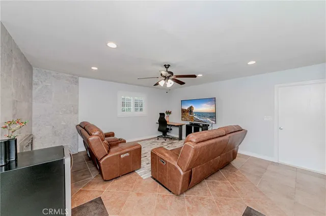 a living room with furniture and a ceiling fan
