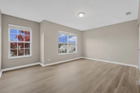 a view of an empty room with wooden floor