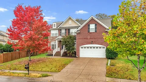a view of a house with a yard and potted plants
