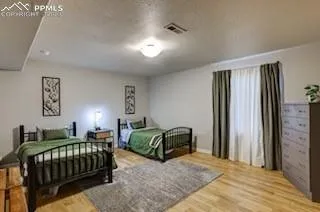 a bedroom with a bed window and a dresser