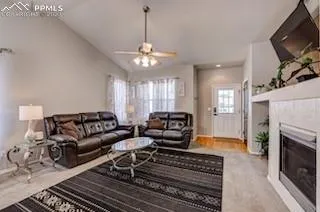 a living room with furniture a fireplace and a flat screen tv
