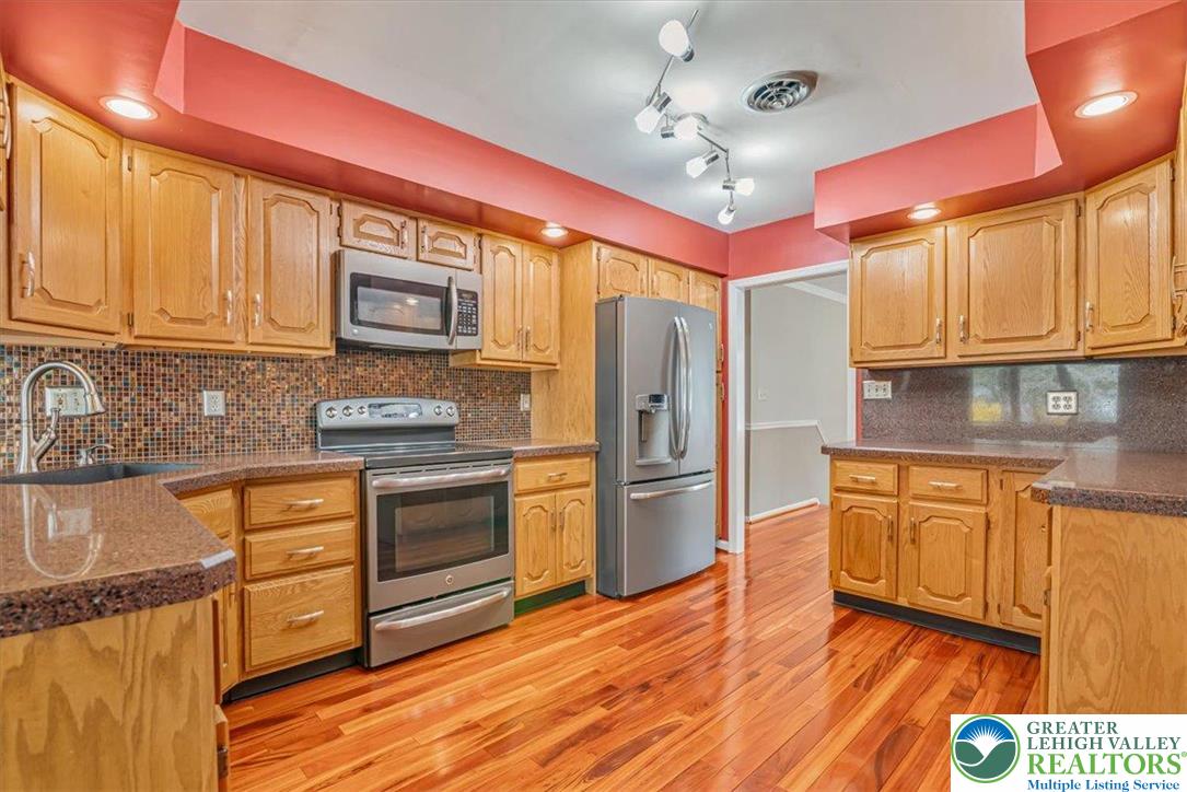 1210 Bluestone Drive Bethlehem, PA 18017 - Photo 17 of 84 a kitchen with stainless steel appliances granite countertop a refrigerator a stove top oven a sink and dishwasher with wooden floor