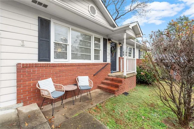 a view of a house with backyard and sitting area