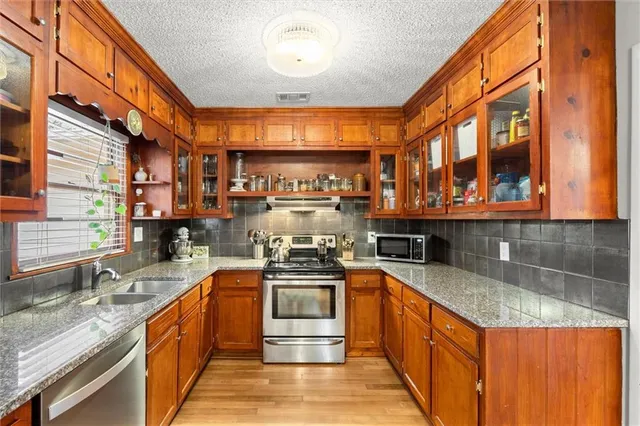 a kitchen with stainless steel appliances granite countertop a stove and a sink