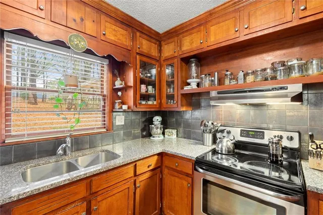 a kitchen with stainless steel appliances granite countertop a sink stove and cabinets