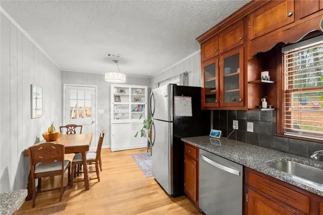 a kitchen with stainless steel appliances granite countertop a refrigerator and a sink