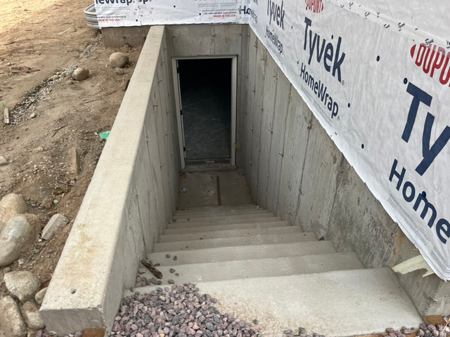 3272 Mohawk Lane Provo, UT 84604 - Photo 7 of 13 Concrete exterior stairs leading to an entry door, with a concrete retaining wall