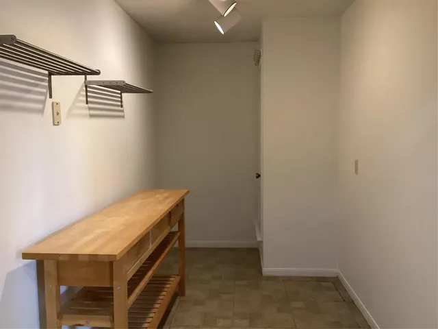 a utility room with a wooden floor and white walls