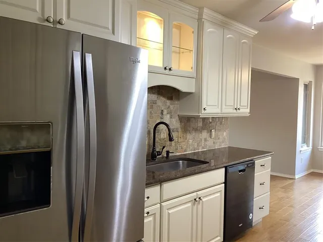 a kitchen with stainless steel appliances granite countertop a refrigerator and a sink