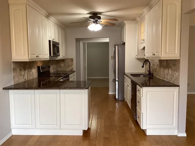 a kitchen with stainless steel appliances a sink stove and cabinets
