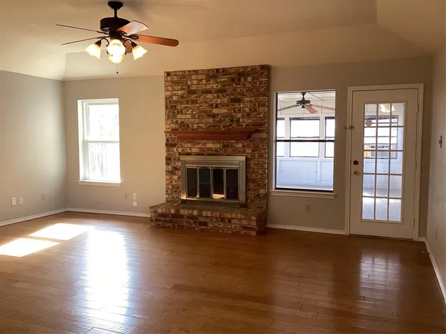 a view of a livingroom with hardwood floor and a ceiling fan to ceiling window