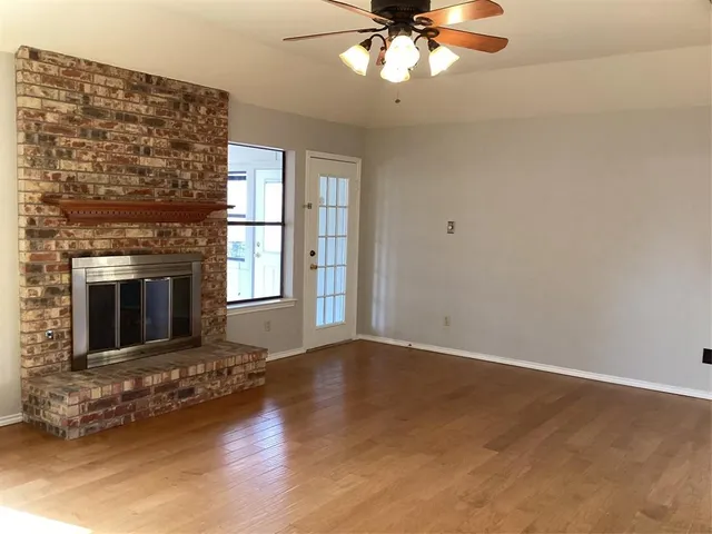 a view of a livingroom with a fireplace a chandelier and windows