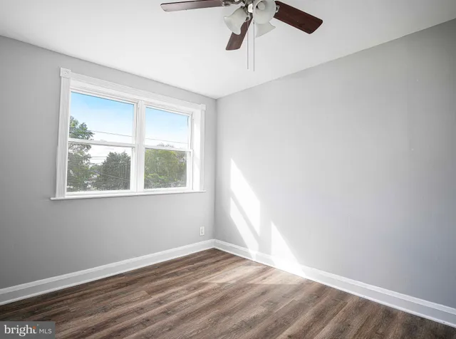 an empty room with a window and wooden floor