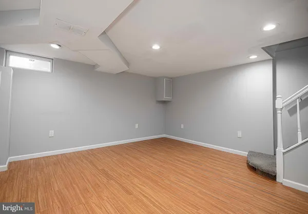 an empty room with wooden floor and entrance