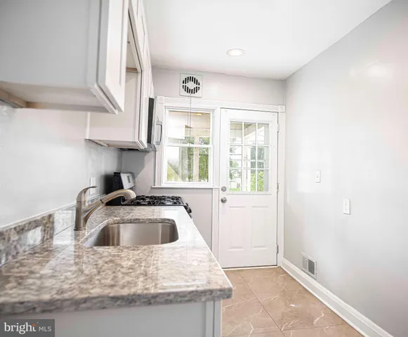a kitchen with a sink a stove and cabinets