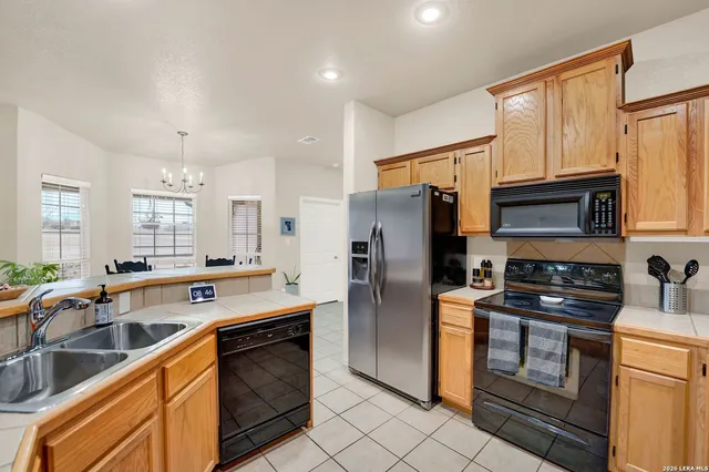 a kitchen with stainless steel appliances granite countertop a refrigerator a stove a sink and a microwave