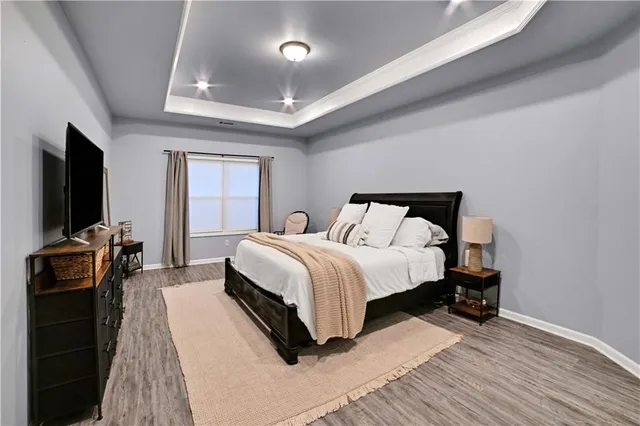 a bedroom with a bed and a flat tv screen on a dresser