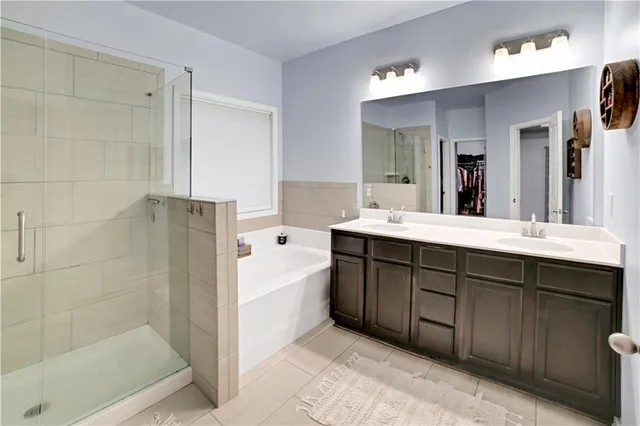 a bathroom with a double vanity sink mirror and shower