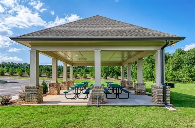 a view of a patio with table and chairs potted plants and floor to ceiling window