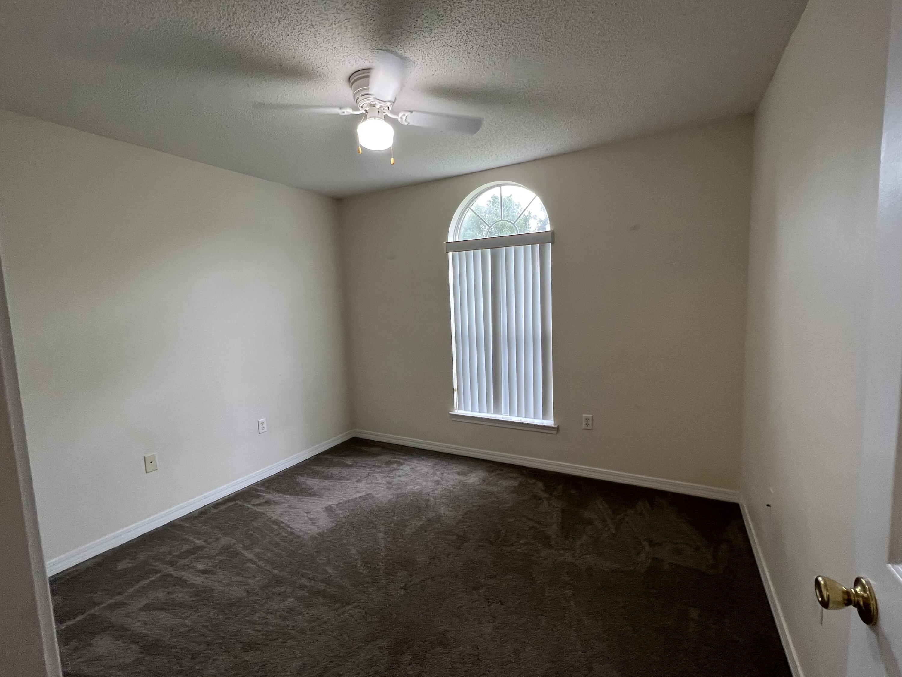 4443 Antioch Road Crestview, FL 32536 - Photo 14 of 24 an empty room with windows and fan