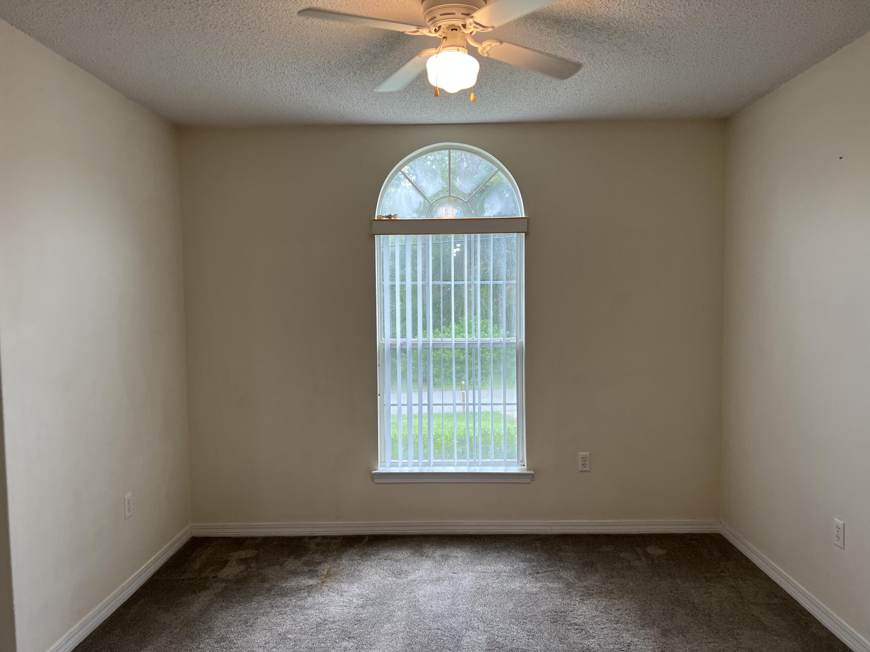 4443 Antioch Road Crestview, FL 32536 - Photo 5 of 24 an empty room with a window and a chandelier fan