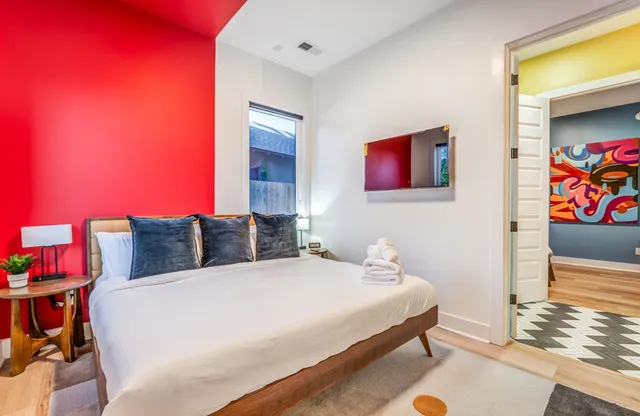 a bedroom with a bed and painting on the wall