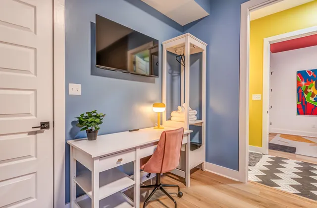 a bedroom with a bed and a dresser next to a window