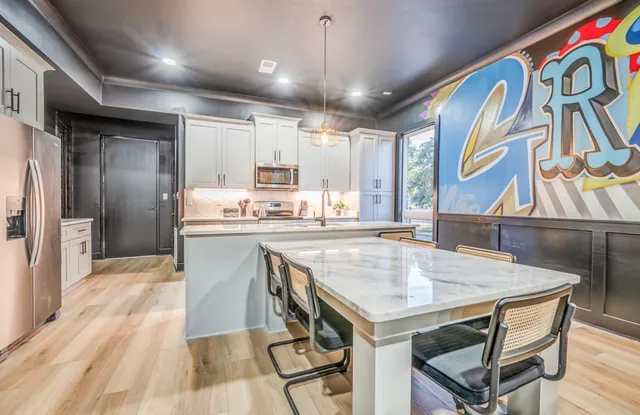 a kitchen with a stove a refrigerator and a dining table