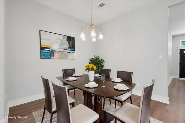 an empty room with wooden floor chandelier fan and windows