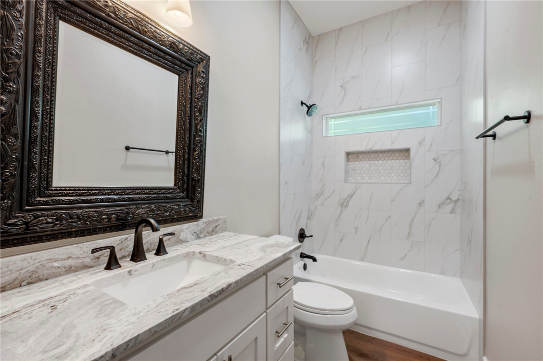 312 Morehead Street Franklin, TX 77856 - Photo 12 of 26 a bathroom with a granite countertop sink toilet and mirror