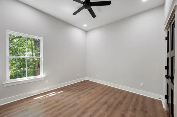 a bedroom with a bed a window and painting on the wall