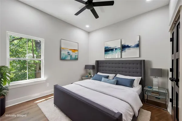 an empty room with wooden floor chandelier fan and windows