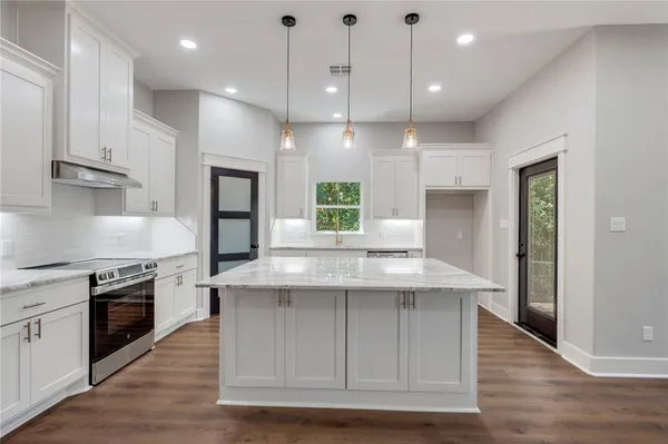 a kitchen with kitchen island a sink stainless steel appliances and cabinets