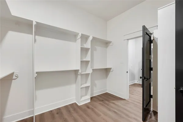 an empty room with wooden floor and closet