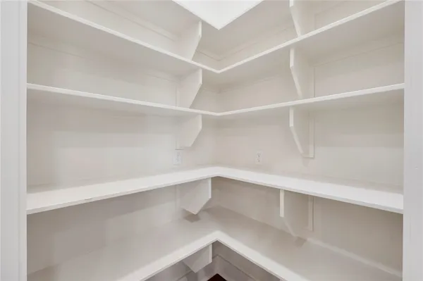 an empty room with wooden floor a fireplace and windows