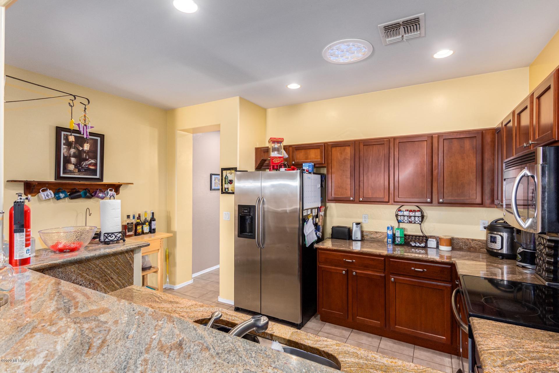 21203 East Reunion Road Red Rock, AZ 85145 - Photo 10 of 26 a kitchen with stainless steel appliances granite countertop a refrigerator a sink a stove and a cabinets