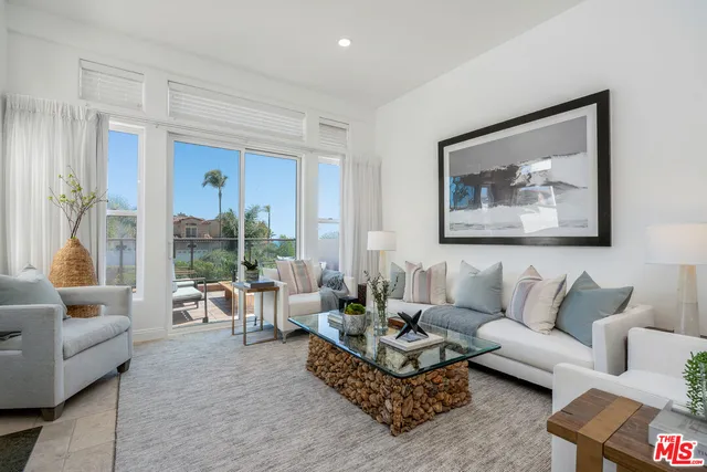 a living room with furniture a fireplace and a floor to ceiling window