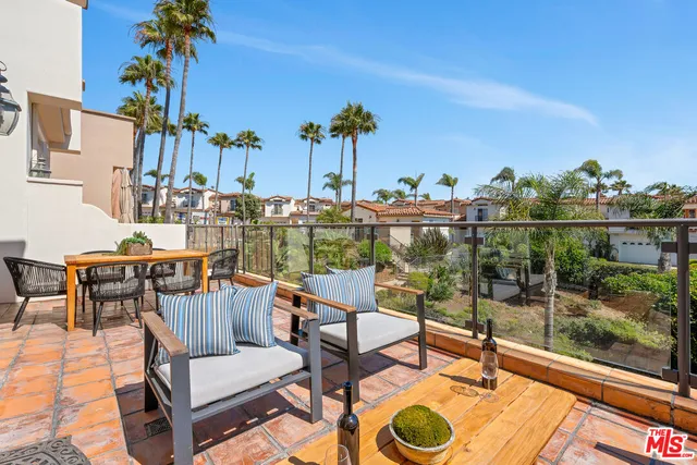 a balcony with table and chairs and wooden floor