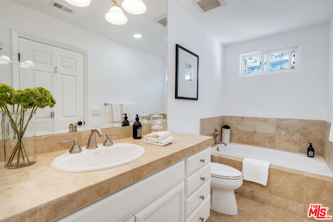 6436 Lunita Road Malibu, CA 90265 - Photo 33 of 54 a bathroom with a granite countertop sink and a mirror