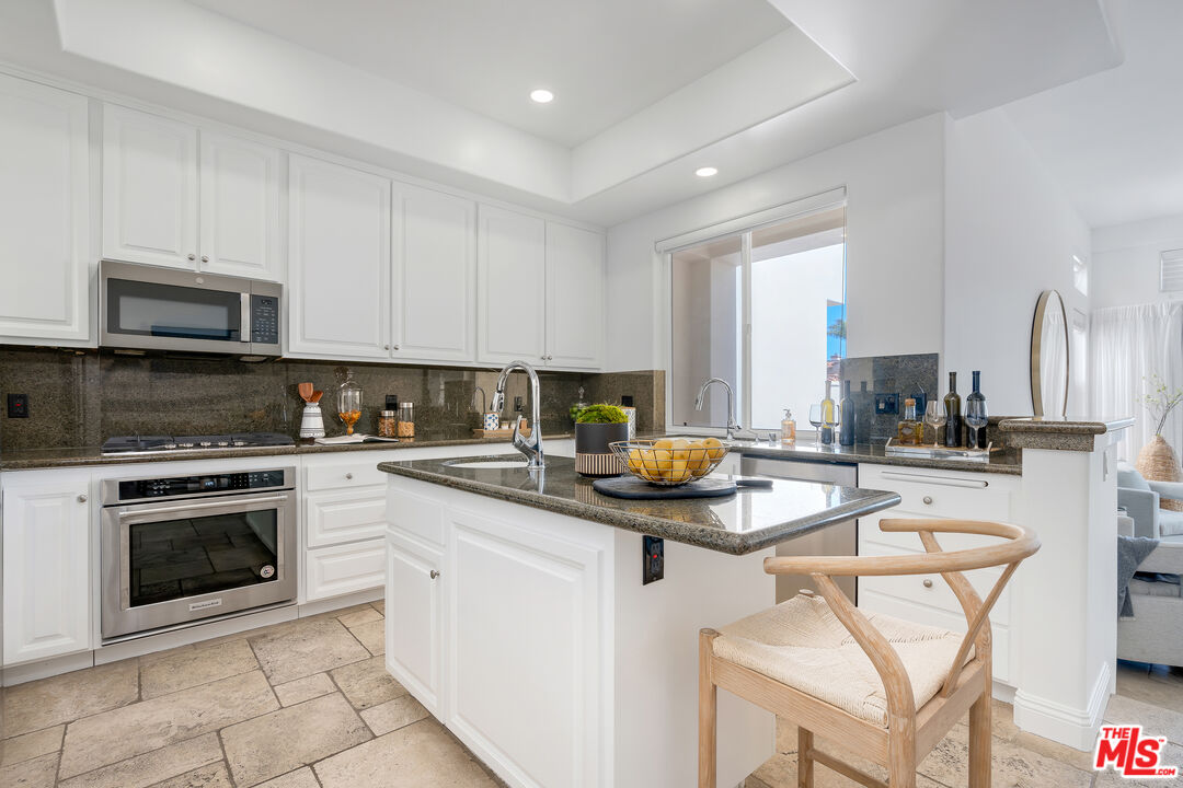 6436 Lunita Road Malibu, CA 90265 - Photo 9 of 54 a kitchen with a stove a sink and a microwave