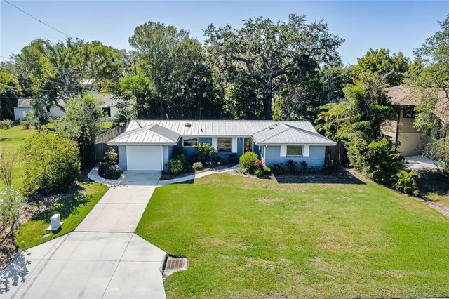 an aerial view of a house with a garden and lake view