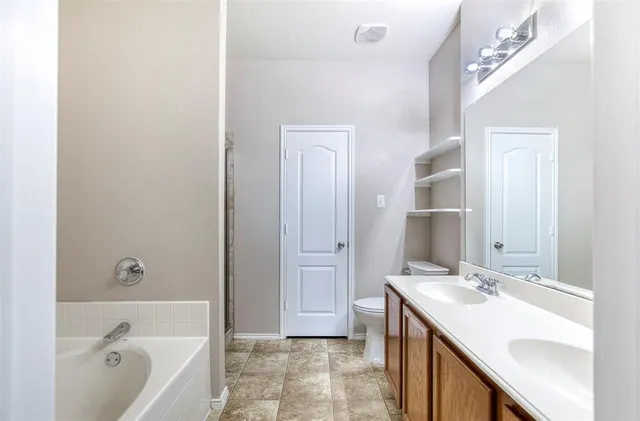 a bathroom with a tub sink and mirror