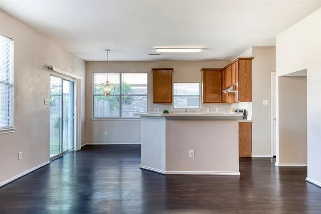 an open kitchen with wooden floor and a window