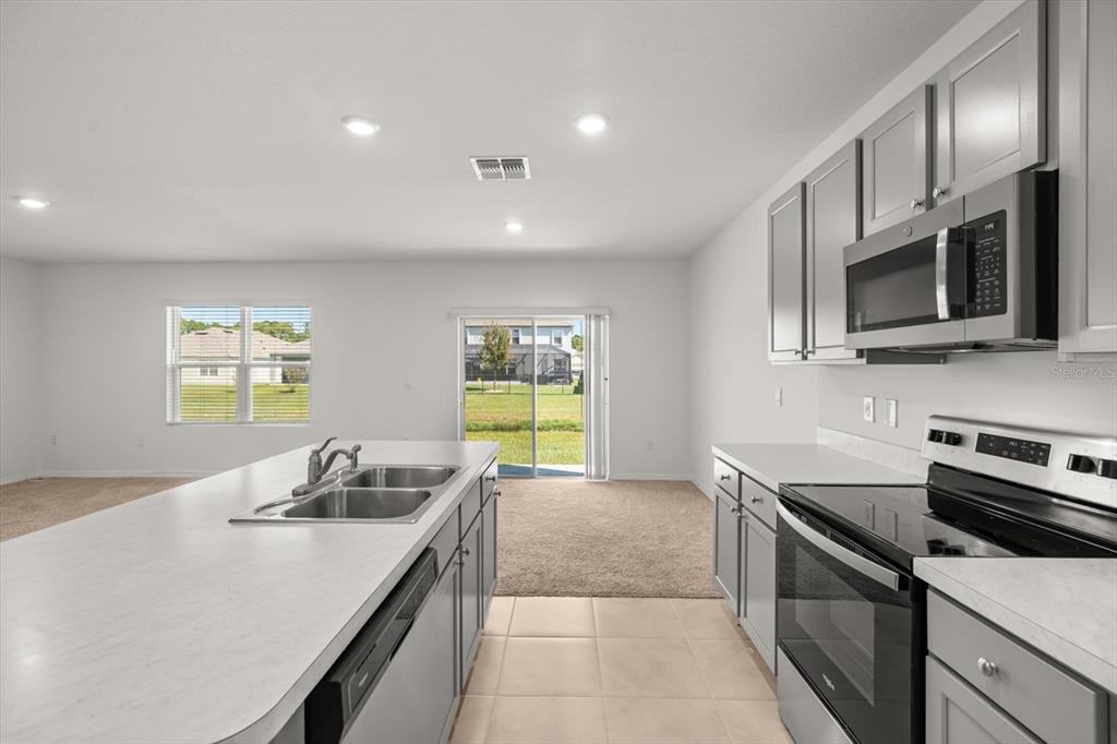 307 Sunset View Drive Edgewater, FL 32141 - Photo 14 of 44 a kitchen with stainless steel appliances a sink stove and microwave