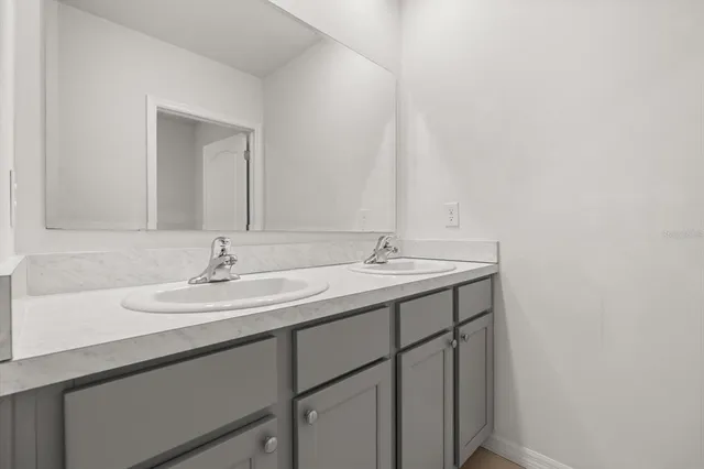 a white bath tub sitting next to a white toilet and vanity