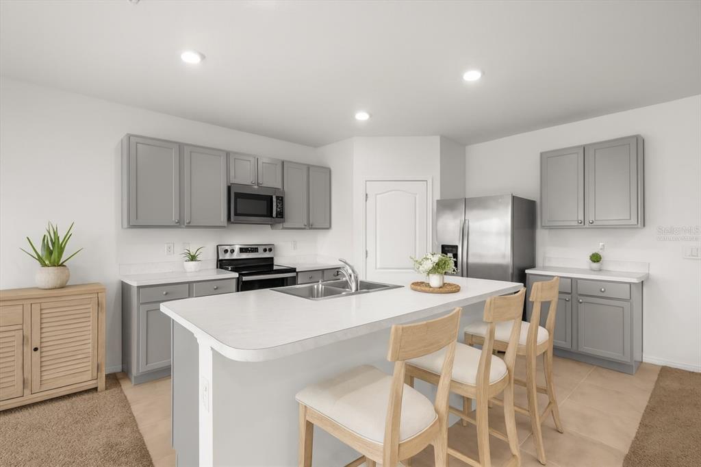 307 Sunset View Drive Edgewater, FL 32141 - Photo 3 of 44 a kitchen with a sink a stove a refrigerator and white cabinets