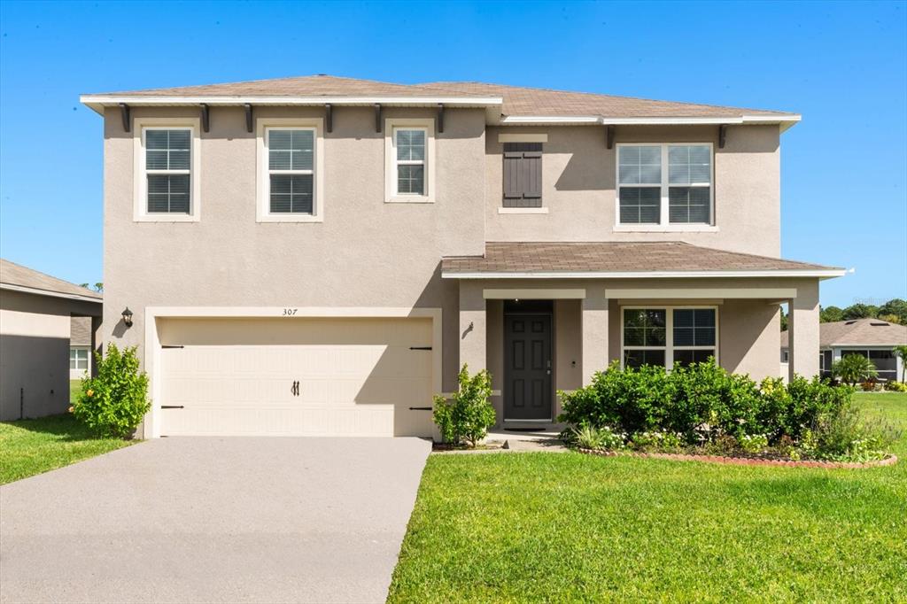 307 Sunset View Drive Edgewater, FL 32141 - Photo 44 of 44 a front view of a house with a yard and garage
